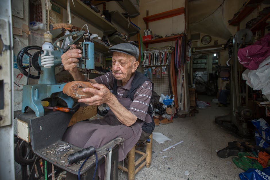 An elderly cobbler repairing a shoe in his traditional workshop, showcasing craftsmanship.