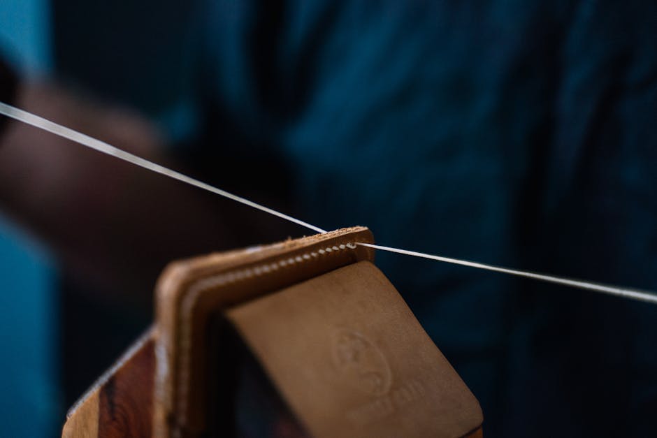 Close-up of handmade leather wallet being stitched, showcasing craftsmanship and precision.